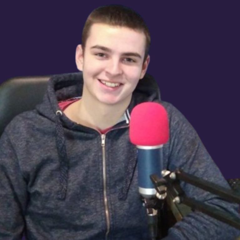 A man seated before a microphone, indicating he is about to speak or broadcast.