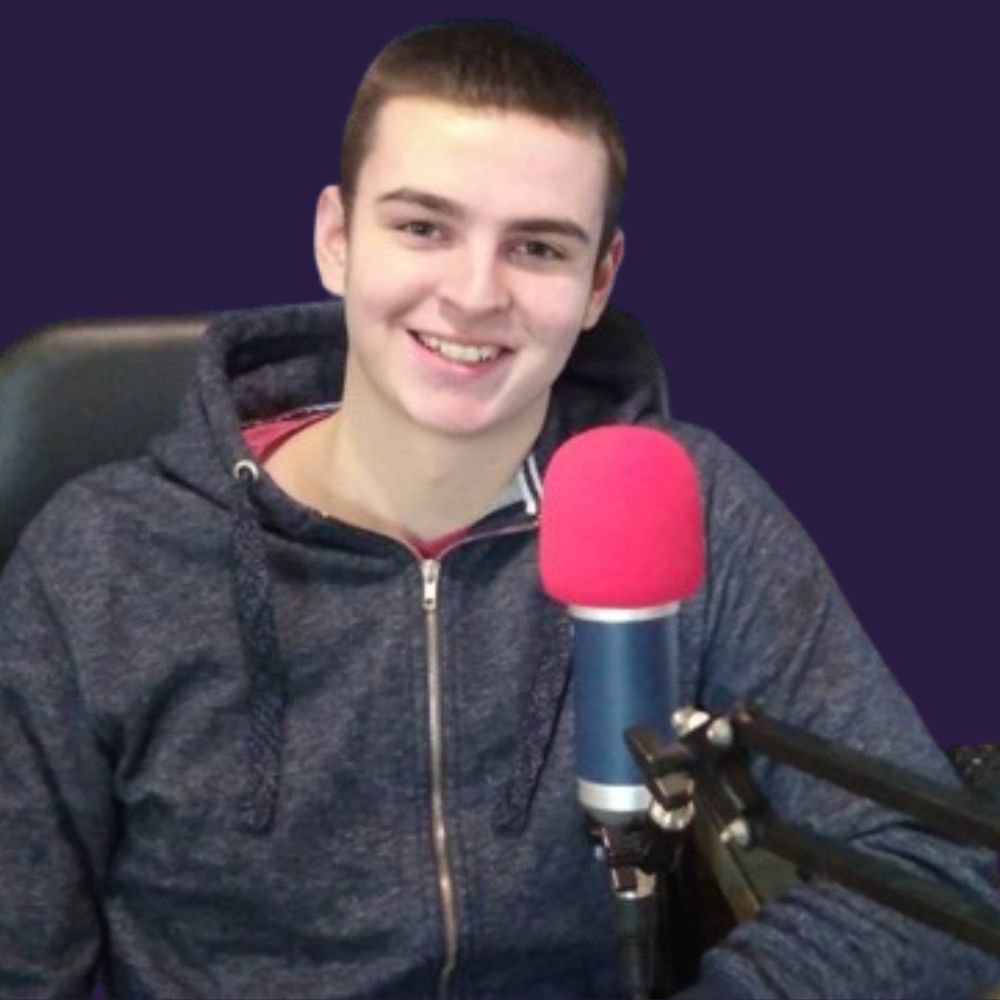 A man seated before a microphone, indicating he is about to speak or broadcast.