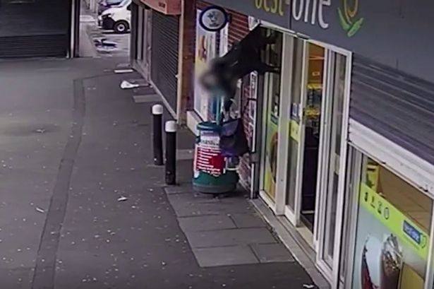 Woman lifted off her feet by shop shutters and left dangling in mid air