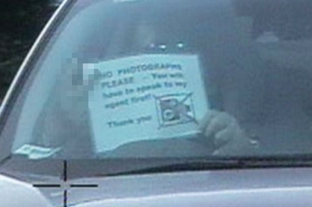 Driver holds ‘No Photographs Please’ sign and flicks Vs at speed camera