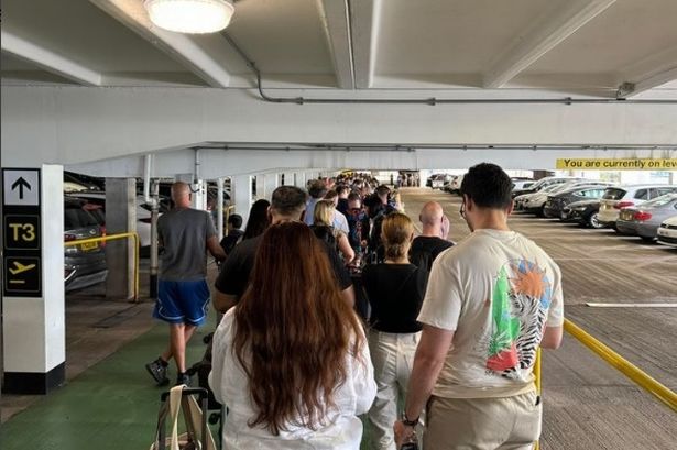 Manchester Airport passengers stuck in queues snaking out of terminal into the car park