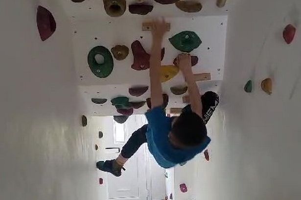 Dad transforms stairs into £700 climbing wall so son with Tourettes can practice