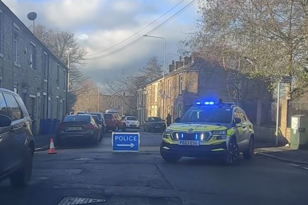 Police shut road after van smashes into parked vehicles